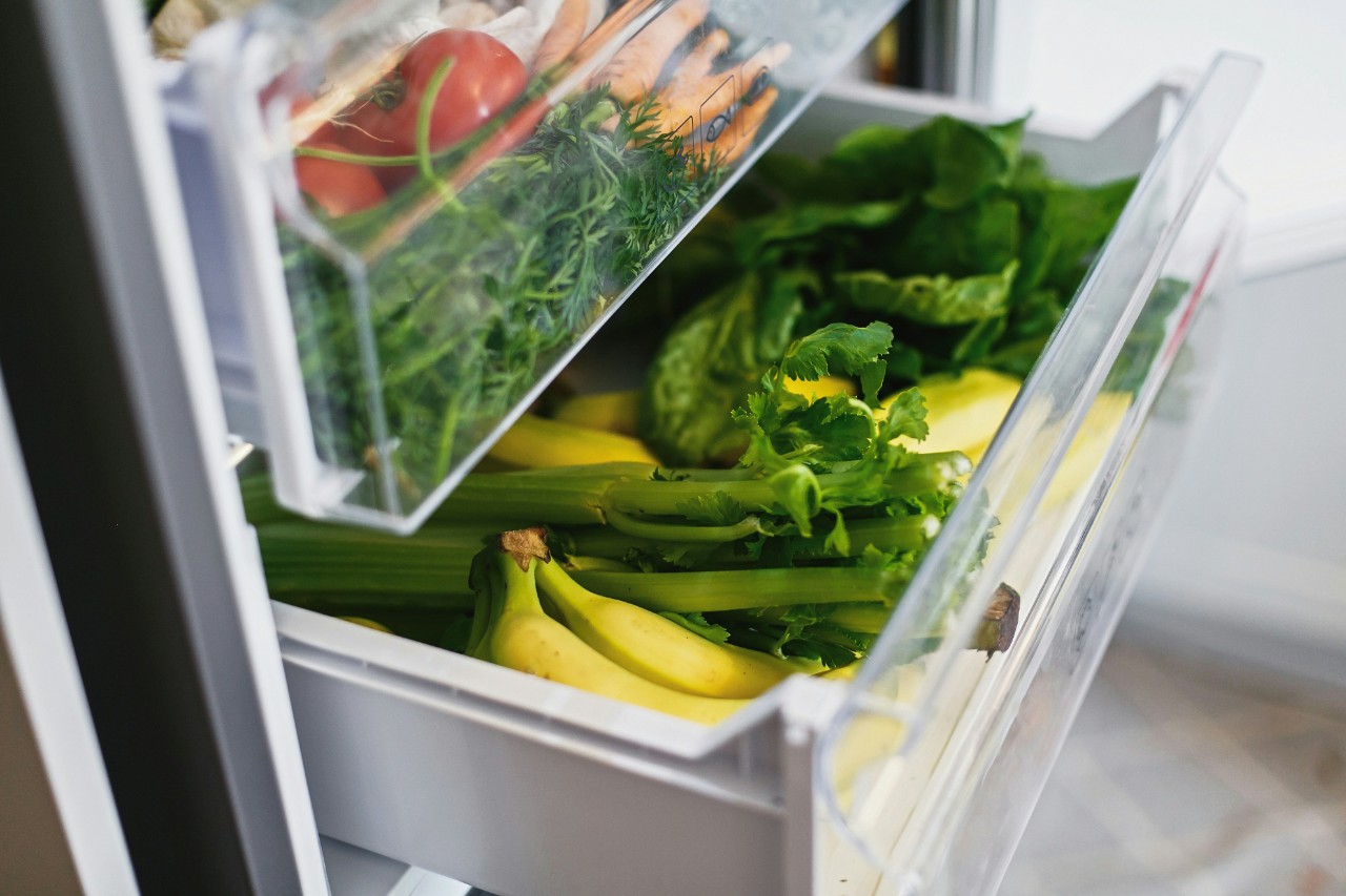 Product drawers in a refrigerator filled with fresh fruits and vegetables from the market.